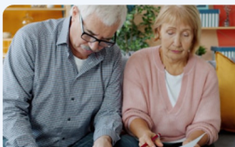 Senior couple reading Medicare plan documents at home